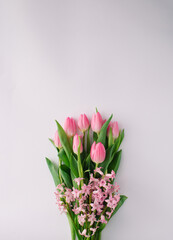 Spring floral arrangement with pink tulips and pink hyacinth on bright background. Minimal concept. Copy space.