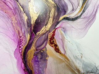 Abstract art with gold — pink-purple background with beautiful smudges and stains made with alcohol ink and golden pigment. Fragment of art with purple texture resembles watercolor or aquarelle.

