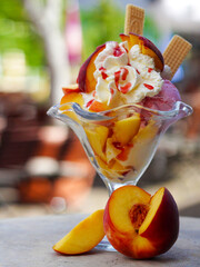 Decorated peach sundae with ice cream, whipped cream and fruits. For ice cream parlors, restaurant and cafe. copy space
