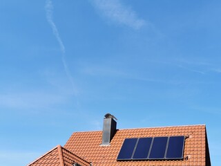 roof  with solar thermo panels and chimney