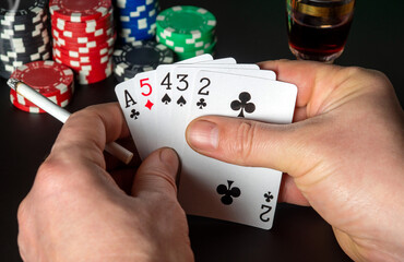 Poker cards with high card combination. Close up of a gambler hands is holding playing cards in poker club