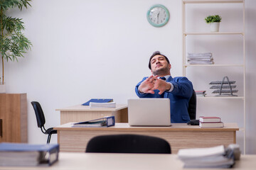 Young male employee being unhappy with excessive work