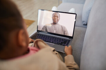 High angle view at African-American girl talking to dad via video chat while social distancing, copy space