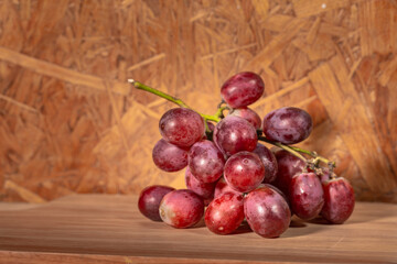 .A bunch of grapes placed on the wood with a wooden background
