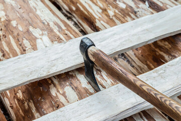 ax among the boards on a wooden background start construction