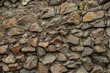 stone wall old and weathered from brown cobblestones