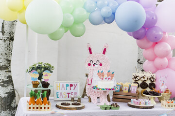 Fototapeta na wymiar candy table decorated with easter bunny and carrots.
