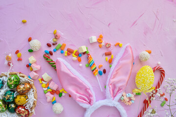 Easter composition with sweets, rabbit ears and tulips. Happy Easter greeting card. Top view, flat lay