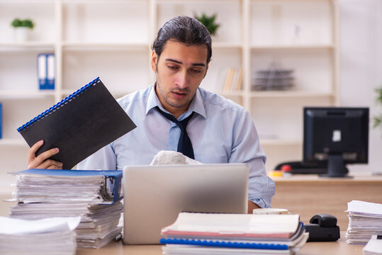 Young Male Employee And Too Much Work In The Office