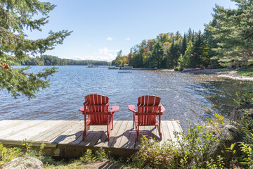 two red chairs on  lake