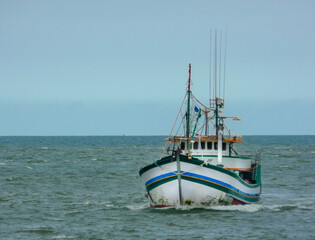Obraz premium SMALL WOODEN FISHING BOAT AT SEA