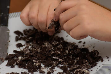Hands breaking cookies to prepare easter egg