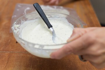 Melted white chocolate with pieces of cookies to prepare easter eggs