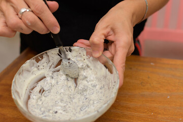 Melted white chocolate with pieces of cookies to prepare easter eggs