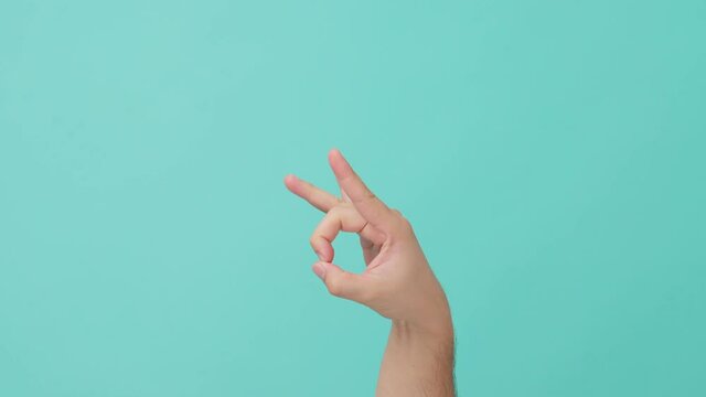 Closeup shot of human hand raising with finger flicking on blue screen