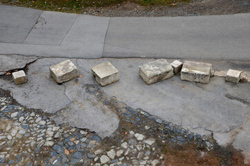 improvised barrier to cars entering the war zone where irregular and variously sized blocks of...
