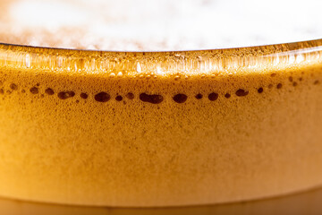 A very close view of frothy bubbles in a clear glass