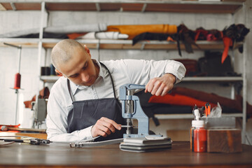 Man in a studio creates leather ware