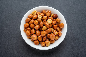 Peanuts in a saucer on a black background