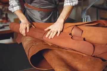 Deurstickers Man in a studio creates leather ware © prostooleh