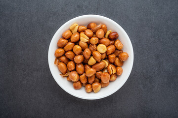 Peanuts in a saucer on a black background