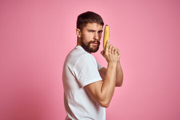 bearded man wearing white t-shirt fruit diet food health pink background