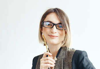 A woman in glasses and a white suit with office supplies in her hands