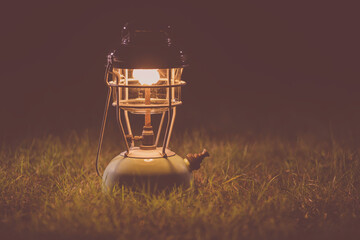 Antique oil lamp Light on the lawn at night, Old camping lights, Ancient lantern.soft focus.Vintage Styled.