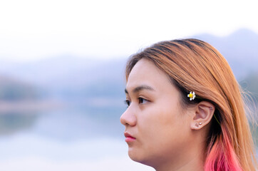 Asian teenager with colorful hair color on lake background. Happiness and be yourself concept.