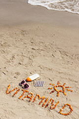 Obraz premium Medical pills, inscription vitamin D and accessories for sunbathing on sand at beach, summer time and healthy lifestyle