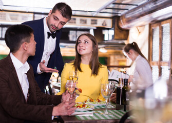 Frendly administrator is interested in the couple about quality of service in restaurant.