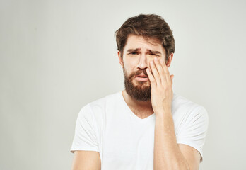 A man in a white t-shirt on a light background emotions model gesturing with hands Copy Space