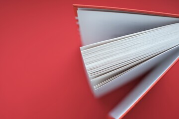 Reading books concept.Learning and knowledge. Book with a red cover on a red background.books close up. Book pages macro.top view, copy space