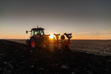 Tractor on the field during sunset.