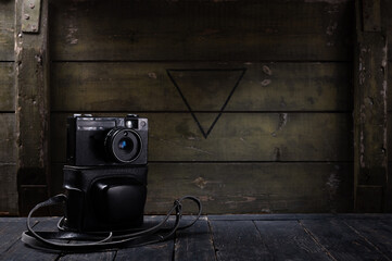 Old Soviet camera and leather case. Vintage photo camera and wooden background.