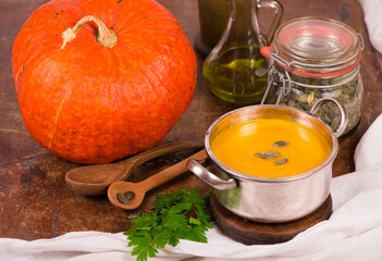 Bowl of pumpkin soup on rustic wooden background