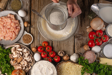 Chef prepares pouring butter for dough, top view on the background of ingredients, culinary recipes.