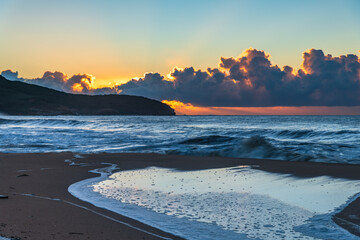 Sunrise at the seaside with low cloud bank