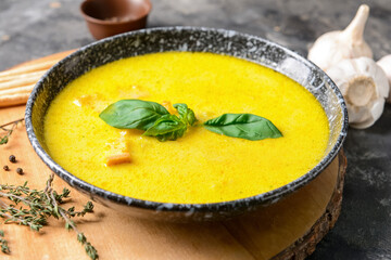 Plate with tasty garlic cream soup on dark background, closeup