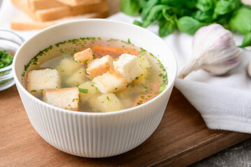 Bowl with tasty garlic soup on table, closeup