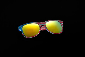 Sunglasses with chameleon mirror glasses in frame with print of flag of America isolated on black...