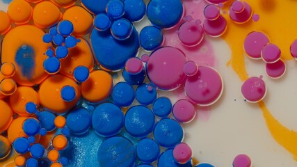 Top view fantastic structure of colorful oil paint and ink bubbles. Chaotic motion. Abstract colorful paint. Movement in liquid. Water surface multicolored texture background. Macro. Pattern, design