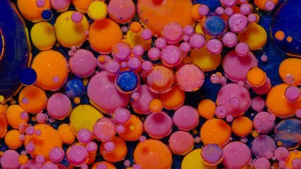 Top view fantastic structure of colorful oil paint and ink bubbles. Chaotic motion. Abstract colorful paint. Movement in liquid. Water surface multicolored texture background. Macro. Pattern, design
