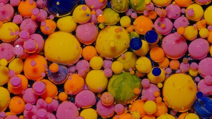 Macro structure of multicolored water paint oil bubbles. Bright colorful acrylic painting. Fantastic surface with chaotic motion liquid. Top view. Mobile phone screen style, theme wallpaper background