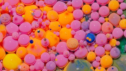 Pink ink bubbles mixed with liquid substance of oil, milk, soap. Floating acrylic paint on colorful surface. Abstract multicolor macro hypnotic transformation themes or wallpaper painting background