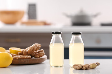 Bottles of healthy ginger juice on table in kitchen