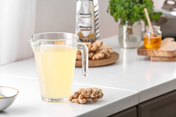 Jug of healthy ginger juice on kitchen counter