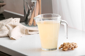 Jug of healthy ginger juice on kitchen counter