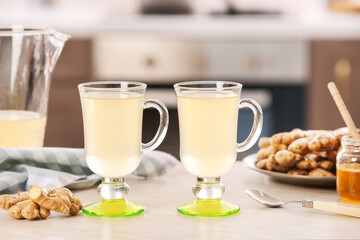 Glasses of healthy ginger juice on table in kitchen