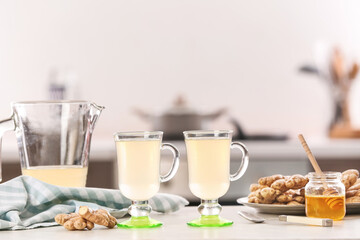 Glasses of healthy ginger juice on table in kitchen